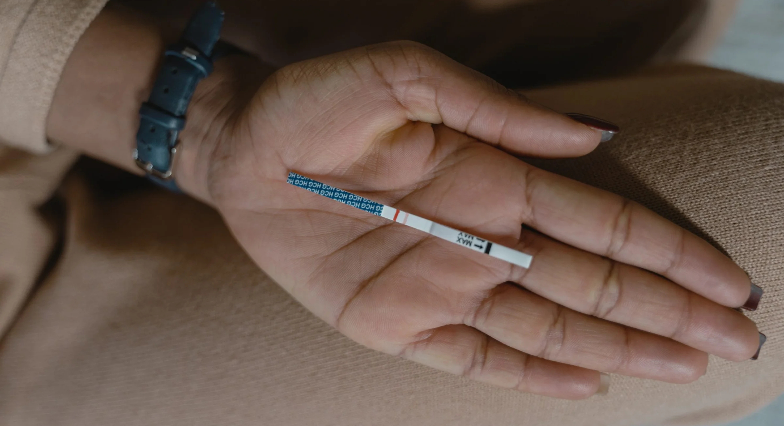 hånd med positiv graviditetstest