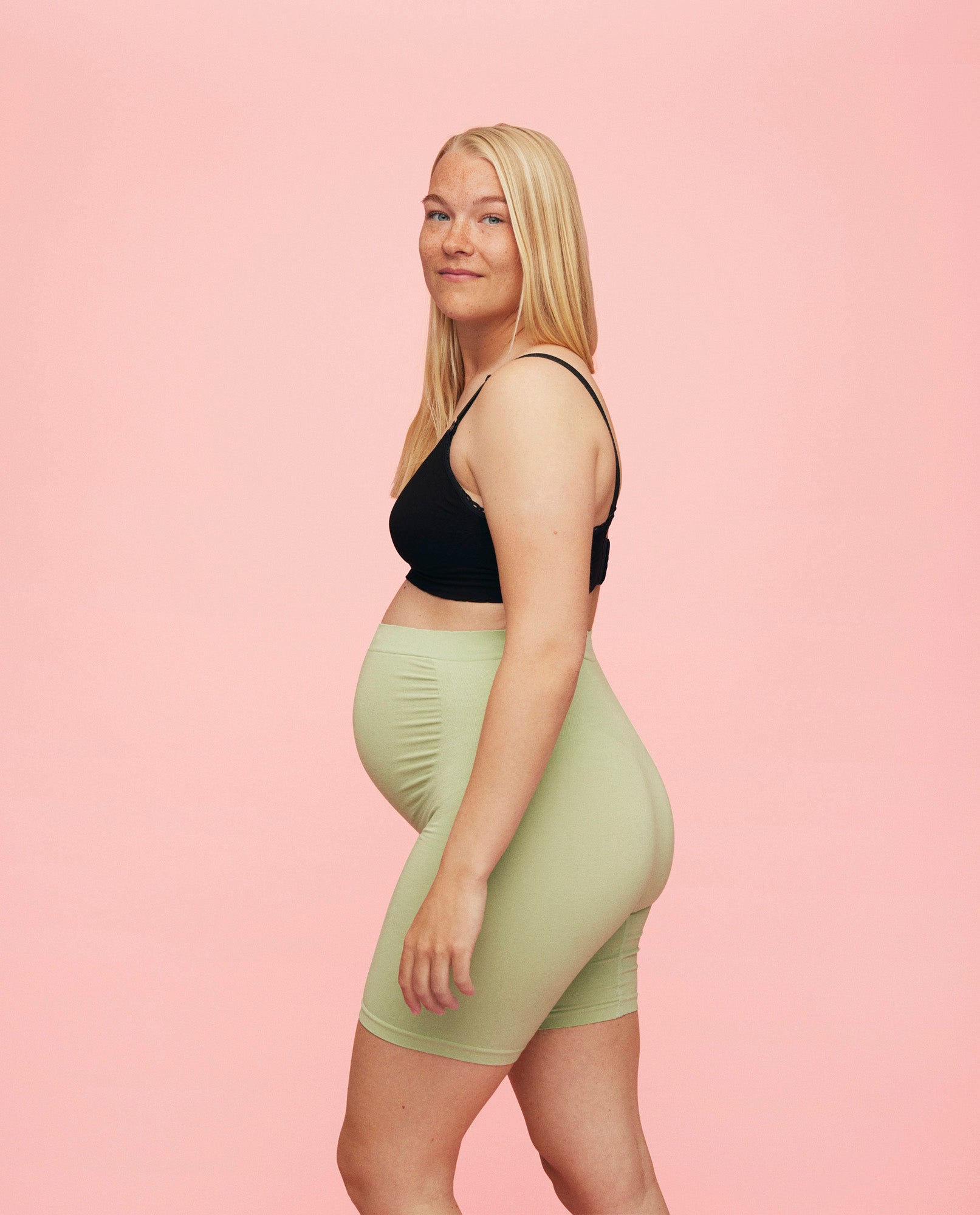gravid kvinde iført momkind belly support shorts til gravide i mintgrøn farve