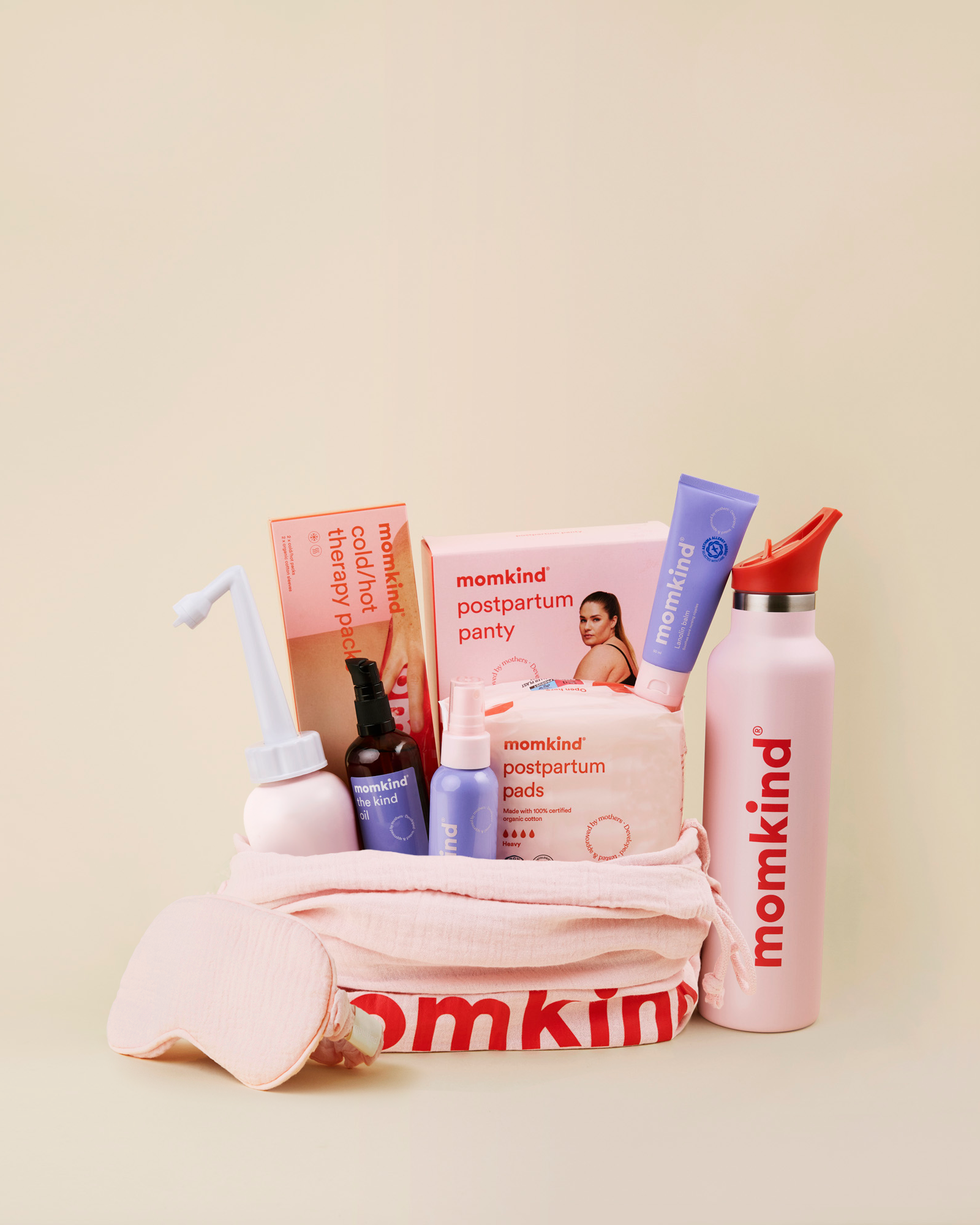 Momkind luksus efterfødselspakke. Posen indeholder skylleflaske, postpartum serum mist, the kind oil, lanolin balm, efterfødselsbind, køle/varme pose, efterfødselstrusser og termo drikkedunk.