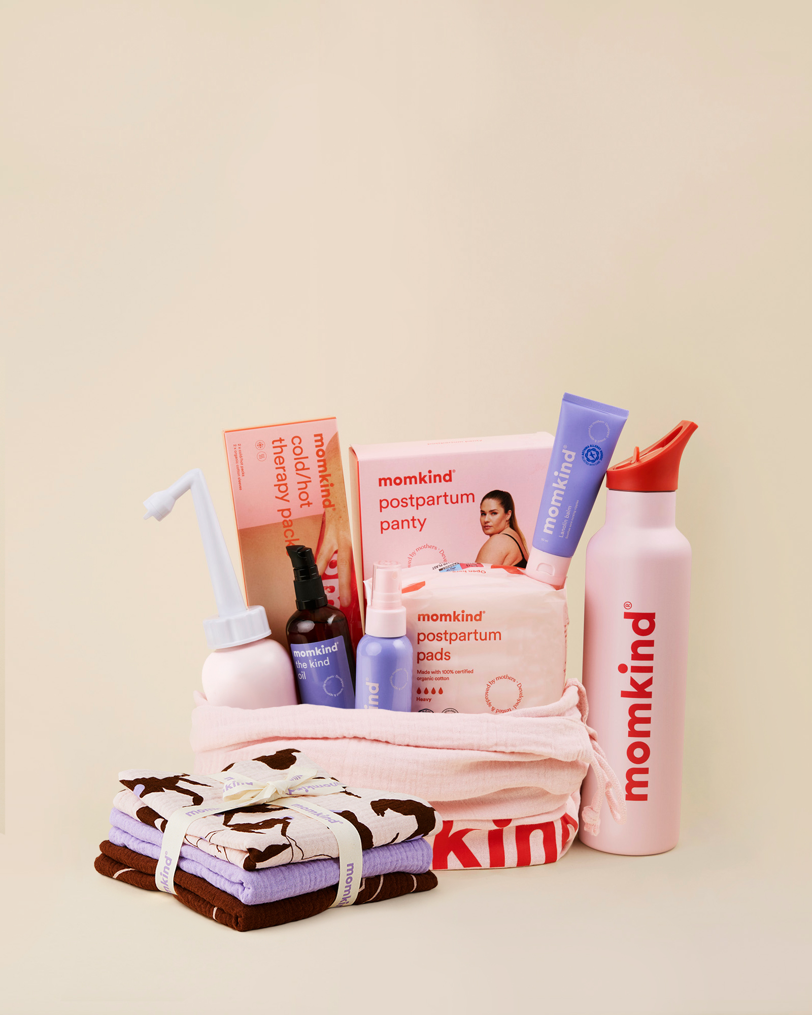 Momkind luksus efterfødselspakke. Posen indeholder skylleflaske, postpartum serum mist, the kind oil, lanolin balm, efterfødselsbind, køle/varme pose, efterfødselstrusser og termo drikkedunk.
