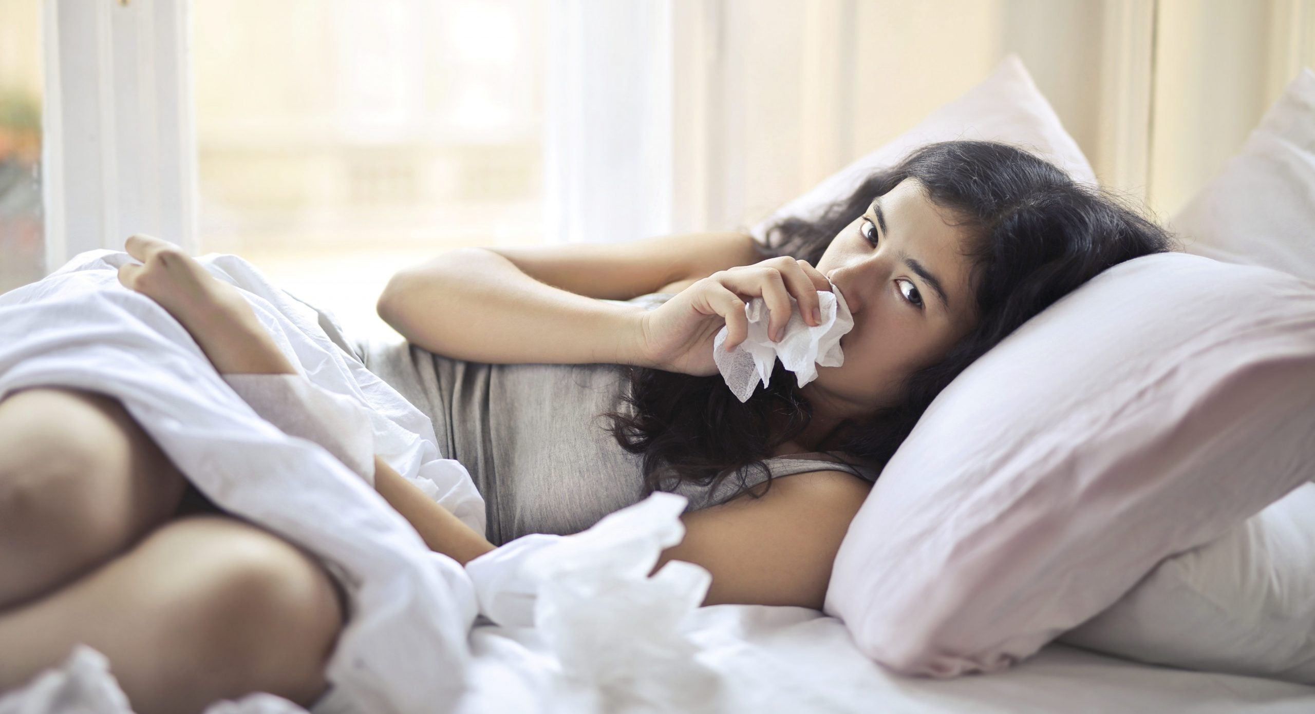 gravid med kvalme kvinde ligger i sengen med graviditetskvalme