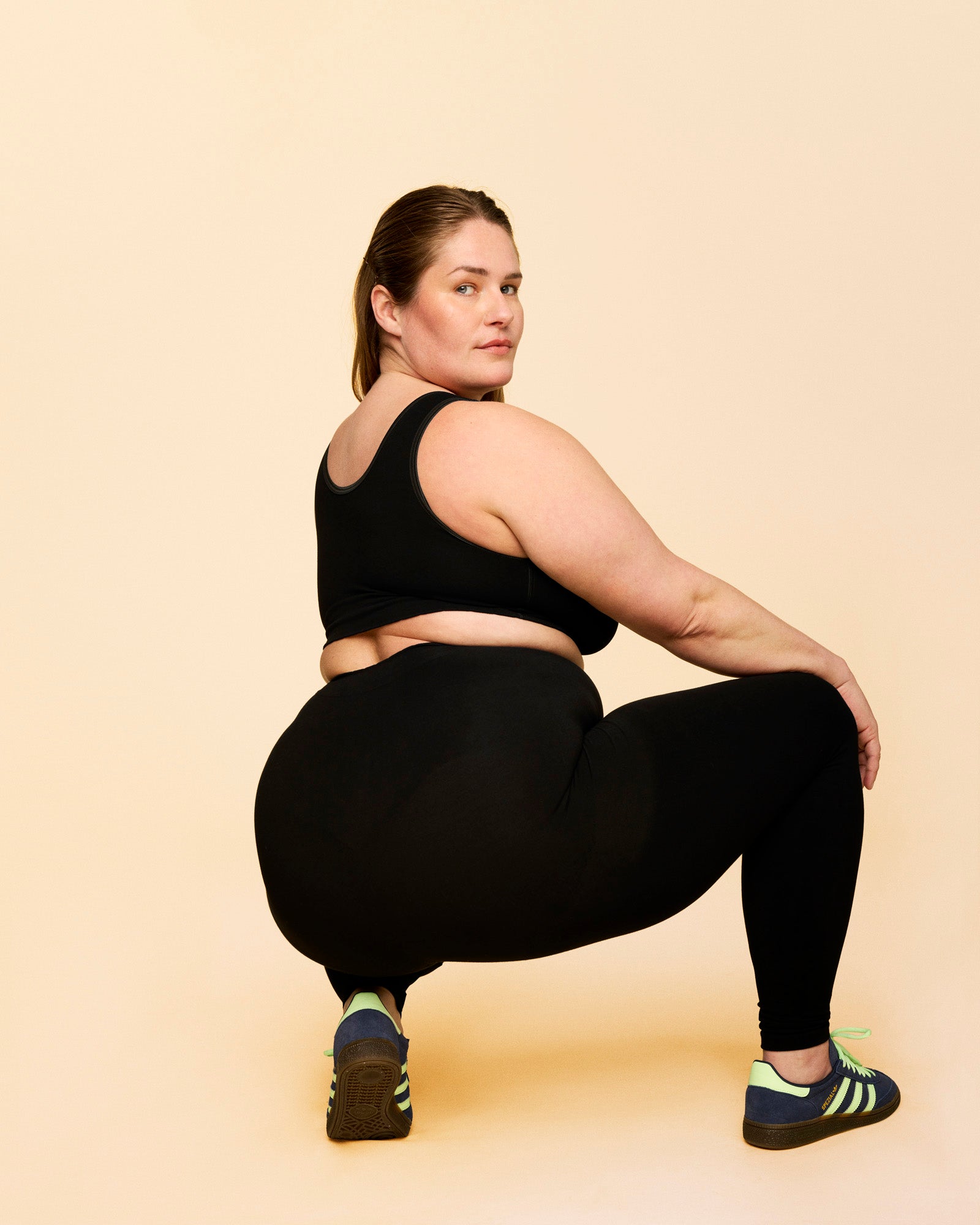 Leggings til efter fødsel. Kvinde står i squat, hvor man kan se leggings ikke er gennemsigtige.
