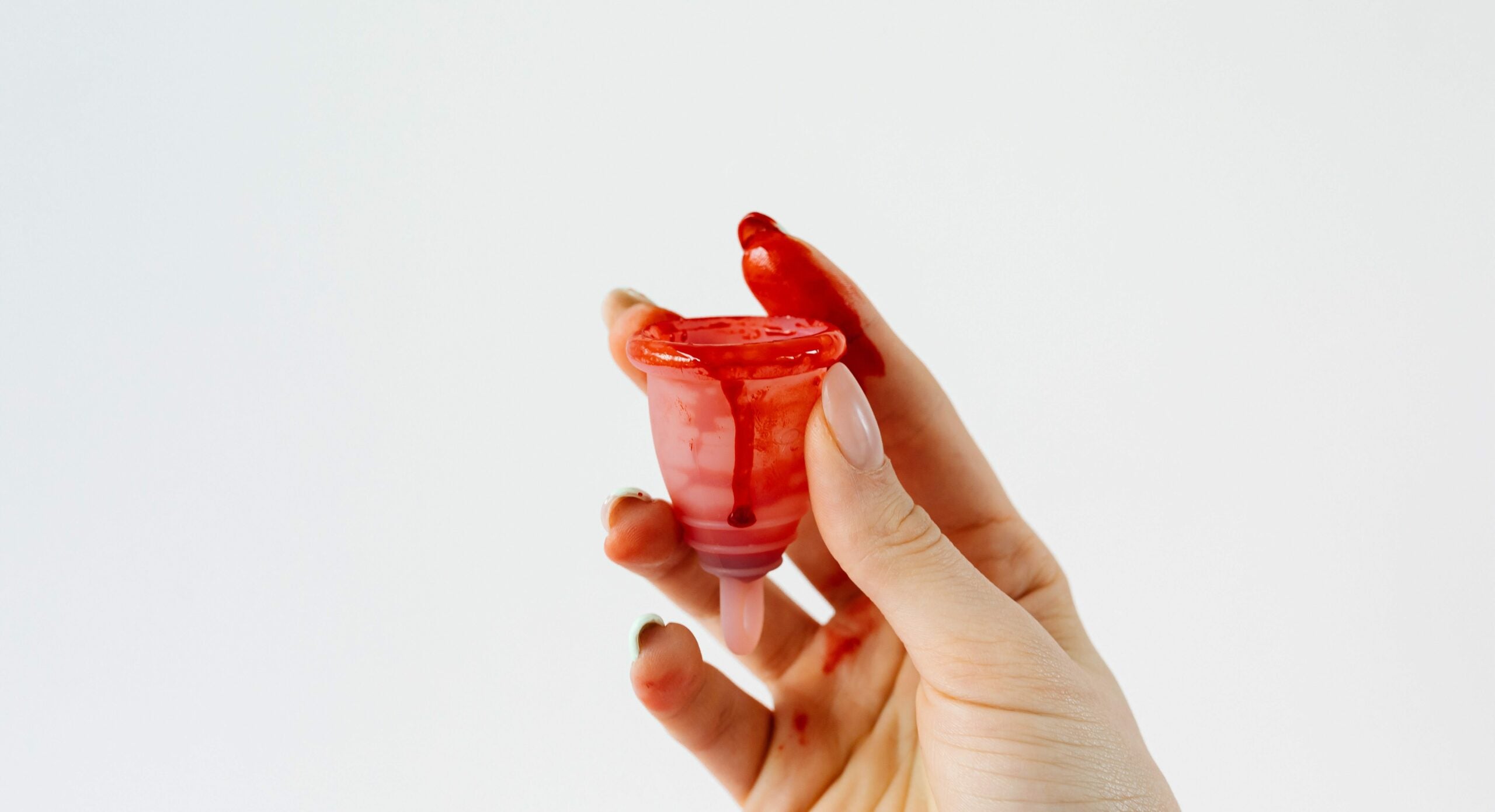 menstruation efter fødsel fingre holder menstruationskop med blod