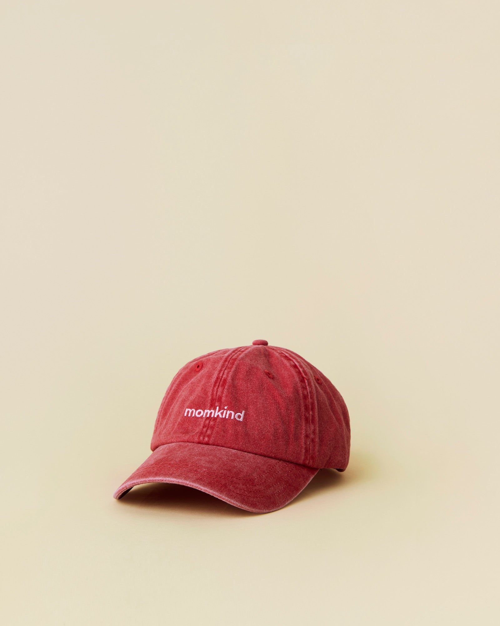 Momkind cap I rød og lyserød logo. Cap ses fra front.