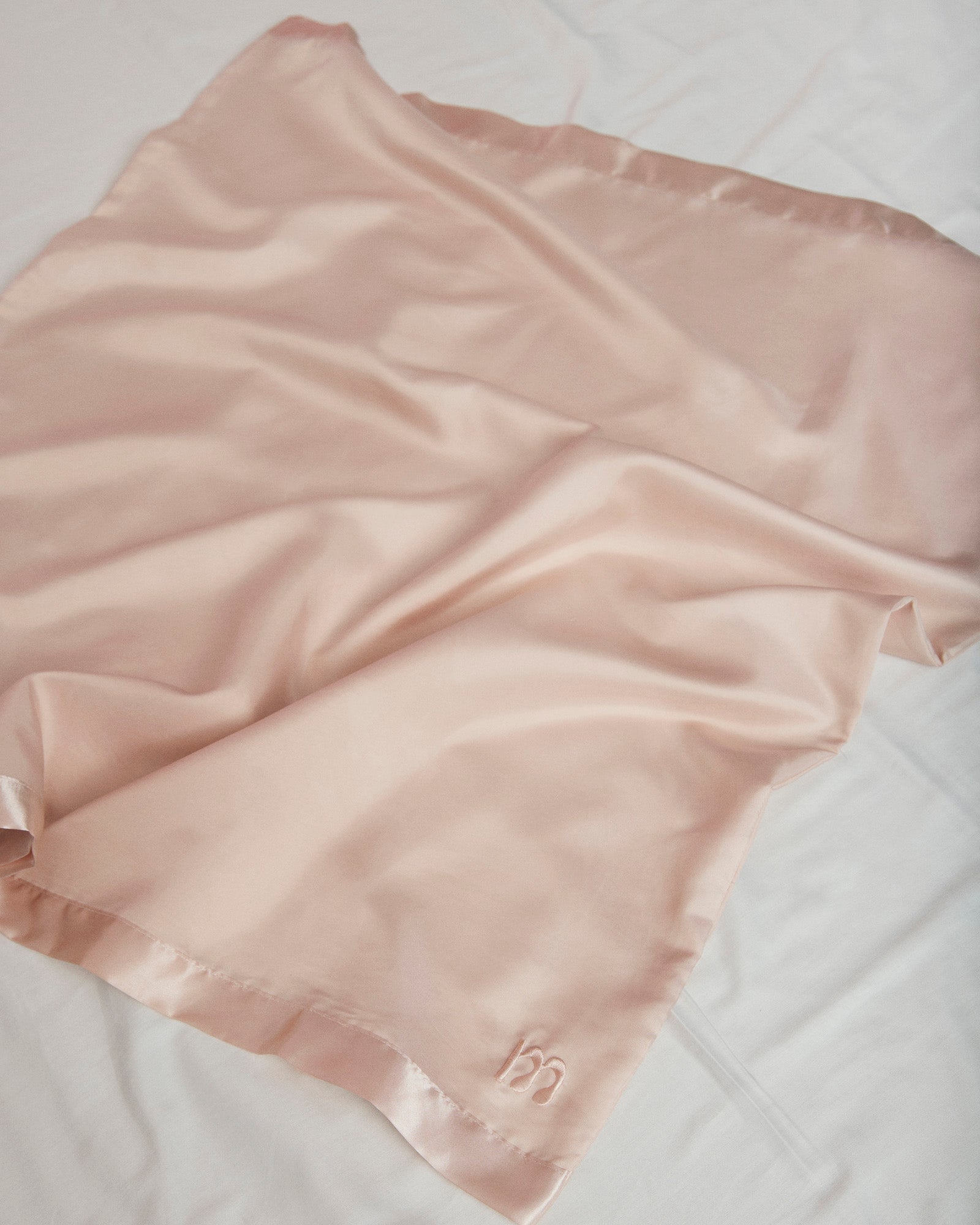 Momkind glidelagen til gravide i lyserød. Det ligger som et glidestykke til sengen.