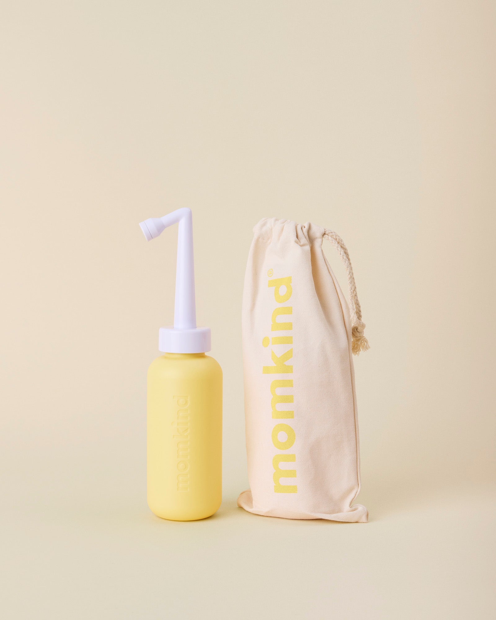 post partum skylleflaske i gul fra momkind står ved siden af tilhørende pose