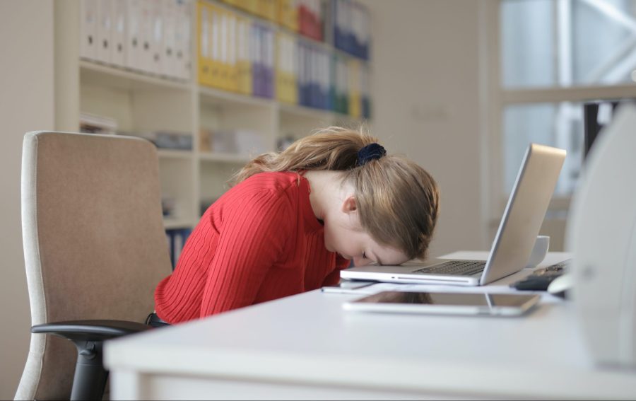 træthed i graviditeten tegn på graviditet kvinde hviler hovedet på computer