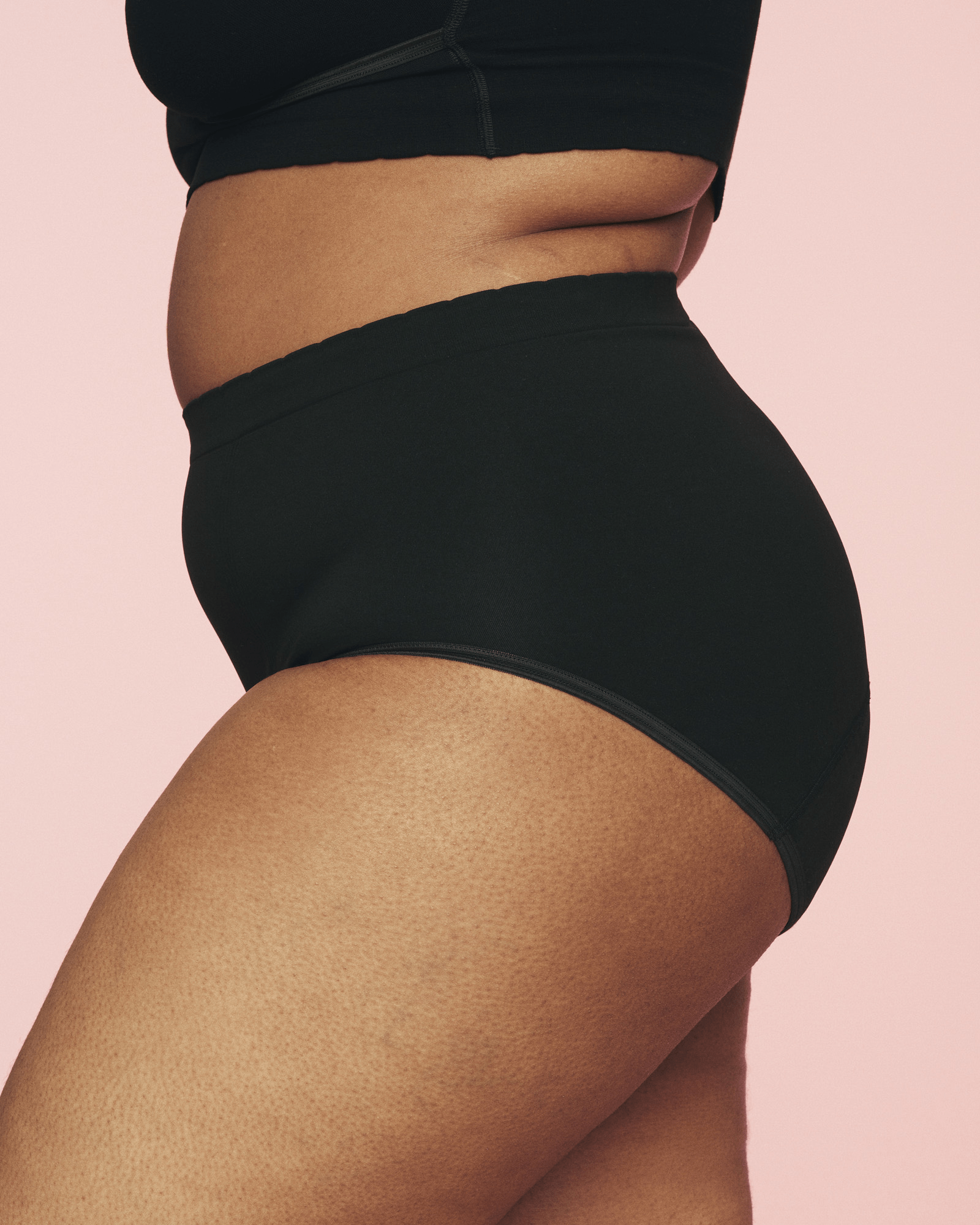 kvinde iført højtaljede menstruationstrusser fra momkind