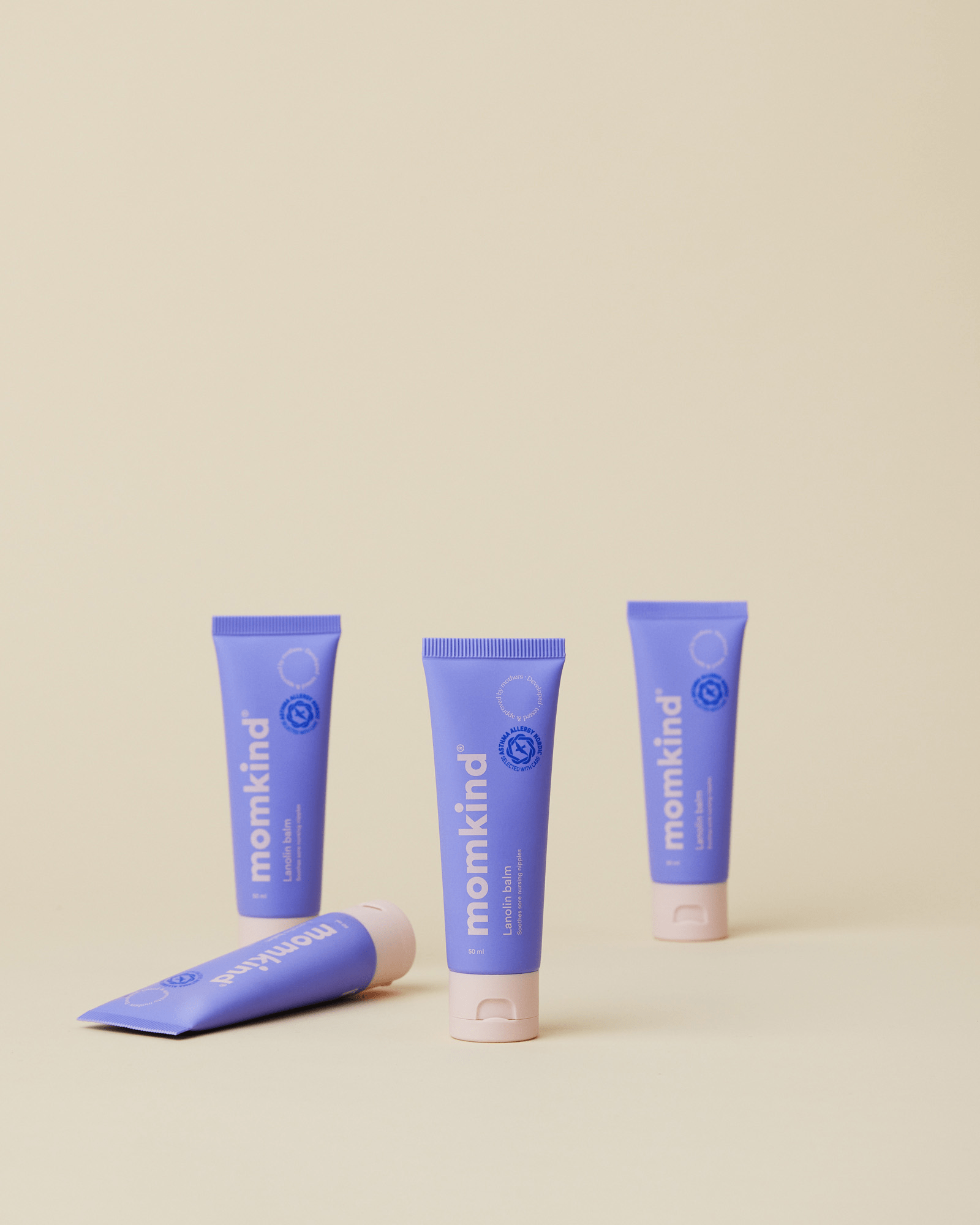 Fire tuber lanolin salve fra momkind. Lilla emballage med lyserød skrift.