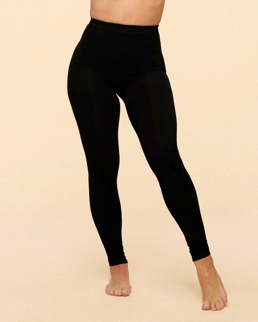 Billede af kvinde iført hugwear leggings i sort. Man kan tydeligt se pasformen på hofterne og langs benene.