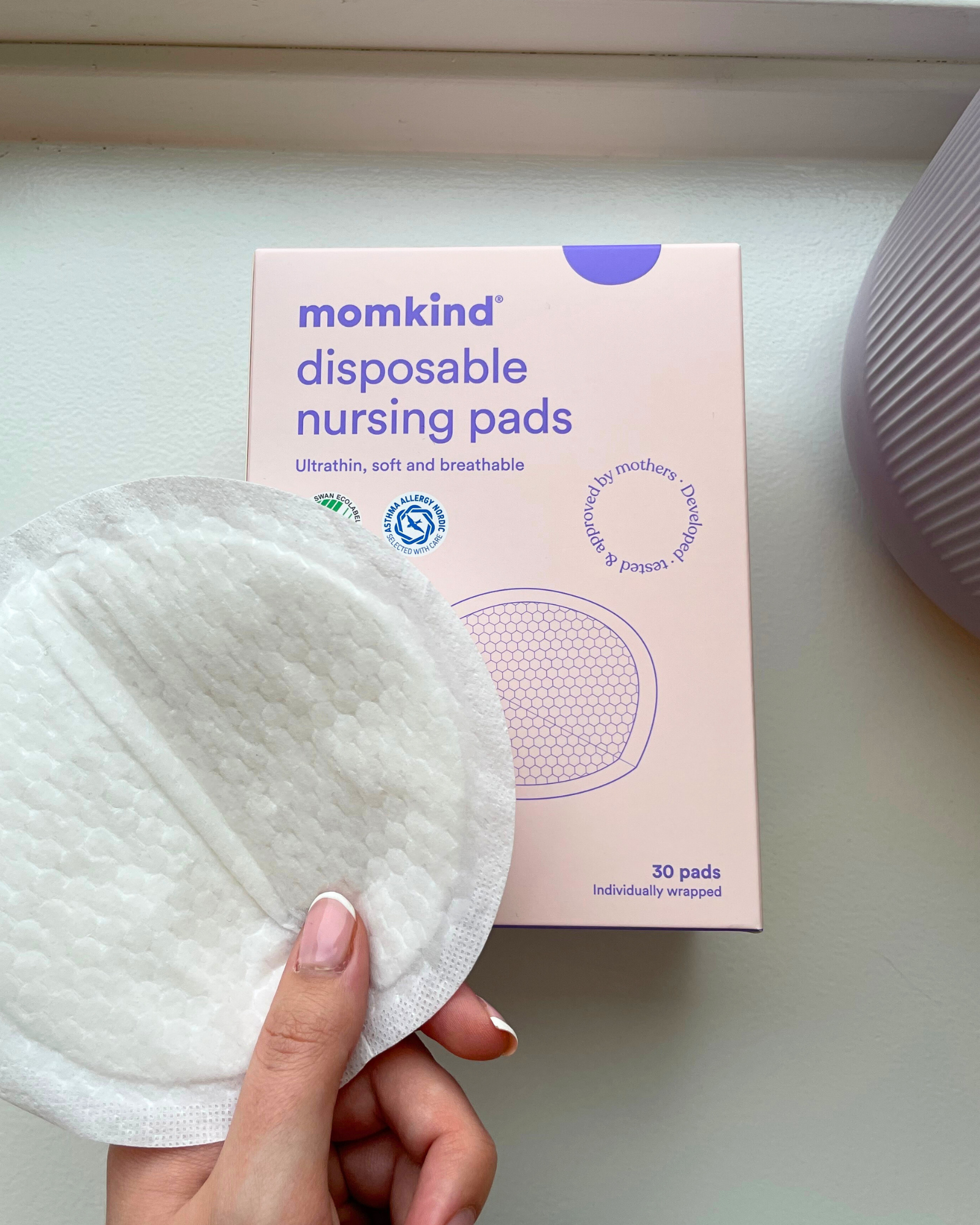 hånd holder engangs ammeindlæg med god sugeevne fra momkind