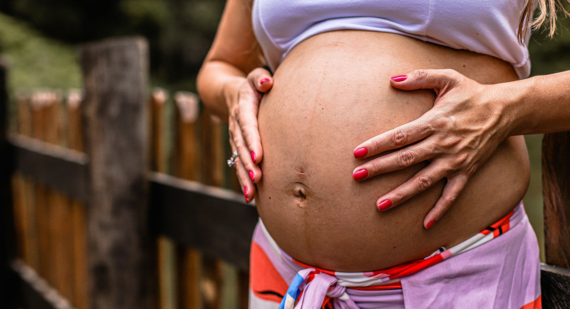 alt hvad du behøver at vide om plukveer gravid kvinde holder hænderne på sin mave