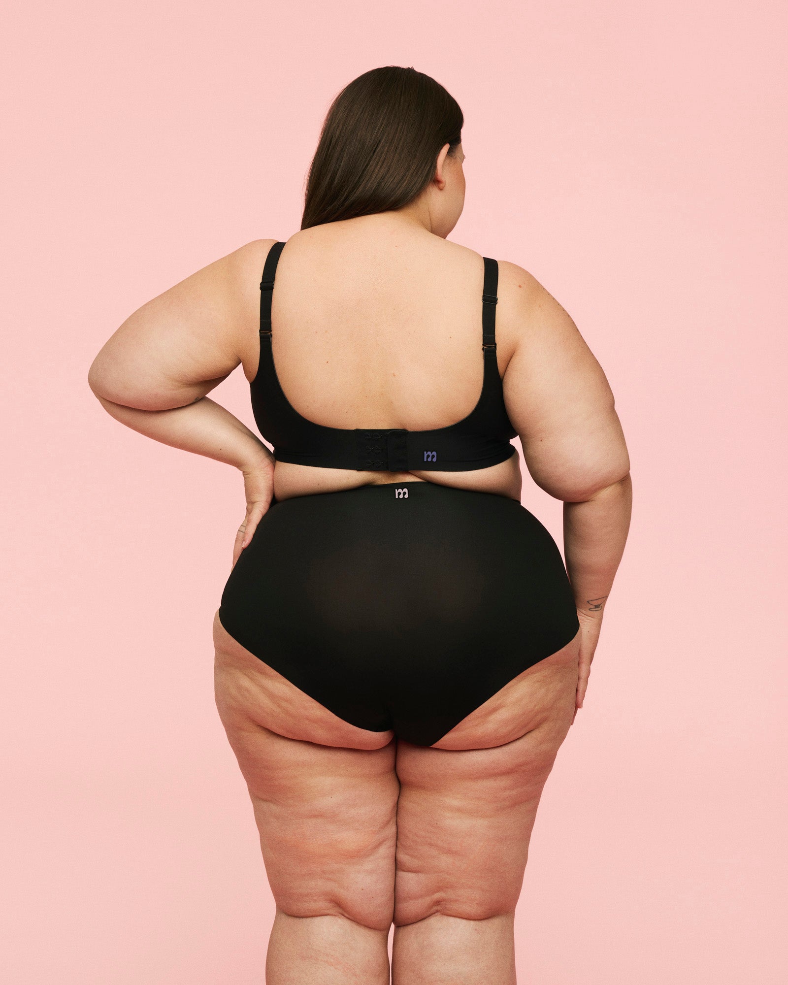 Kvinde iført postpartum briefs high waist fra momkind. Hun ses bagfra, hvor trussens pasform ses. 